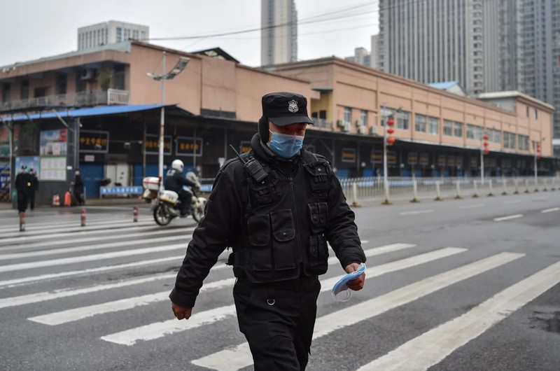 Một sĩ quan cảnh sát tuần tra ở chợ hải sản Huanan, Vũ Hán nơi mà các nhà khoa học tin là khởi điểm của dịch bệnh (Ảnh: Washington Post)