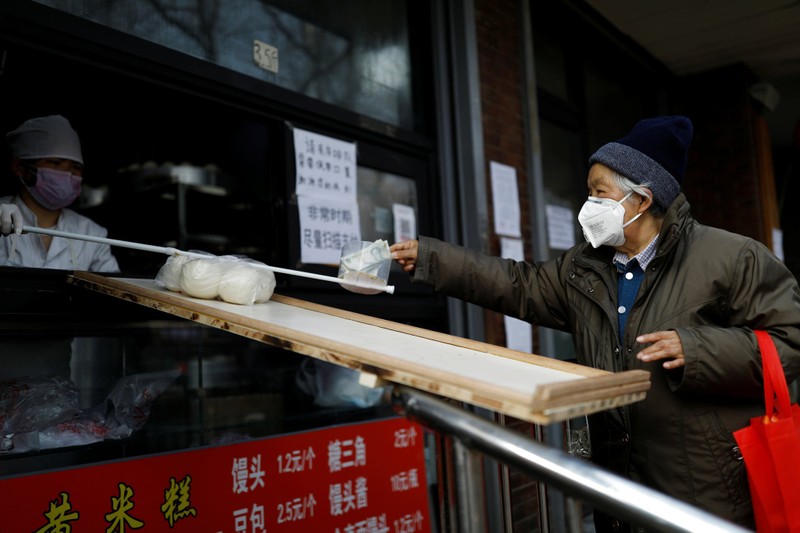Lo sợ virus corona, người bán hàng ở Bắc Kinh không dám trực tiếp nhận tiền của khách mua (Ảnh: Reuters)