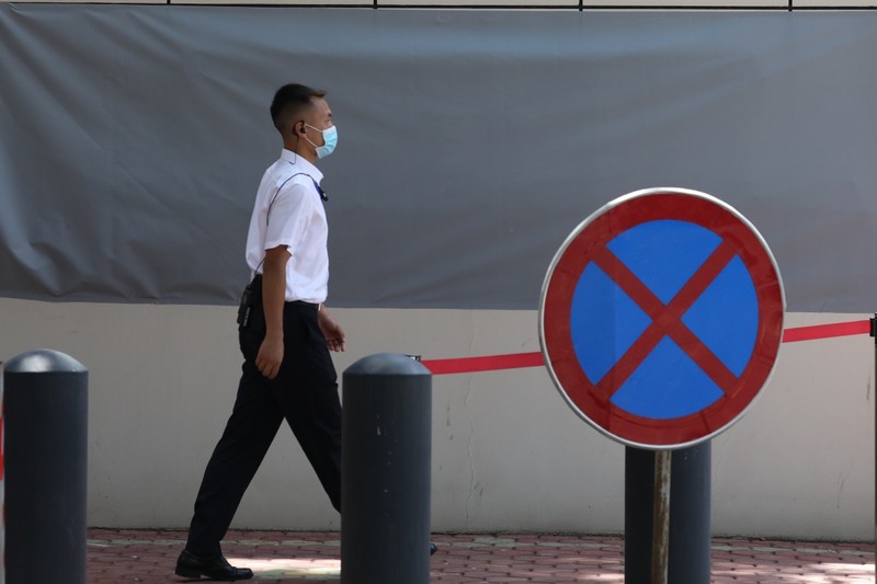 Một nhân viên an ninh băng qua tấm biển cấm vào bên ngoài tòa lãnh sự quán Mỹ ở Thành Đô (Ảnh: SCMP)
