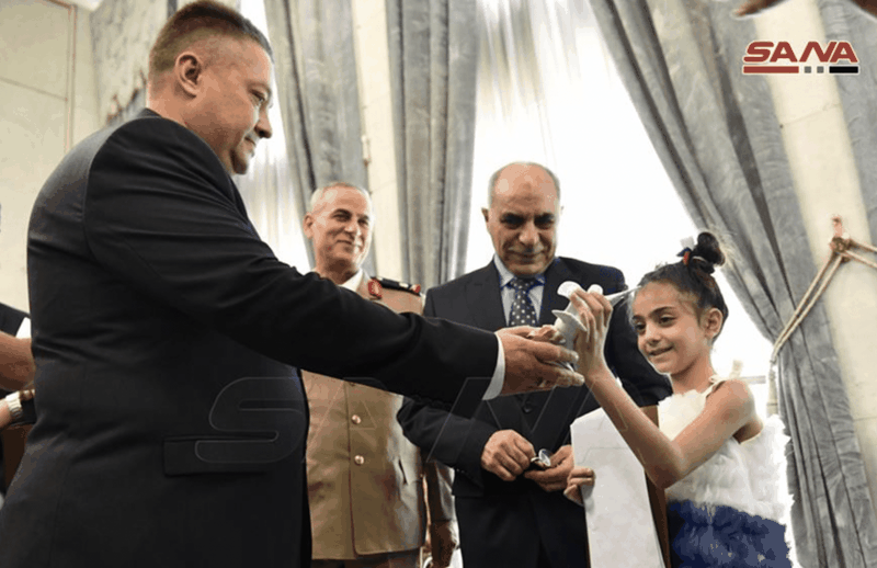 Imam Ali, bé gái 9 tuổi, được trao thư và quà của Tổng thống Putin tại Đại sứ quán Nga ở Syria (Ảnh: SANA)