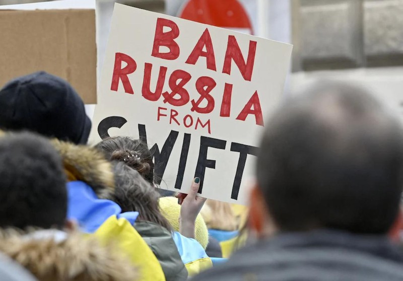 Người biểu tình giơ tấm biển "Loại Nga khỏi SWIFT" trước Đại sứ quán Nga tại Vienna, Áo (Ảnh: AFP)