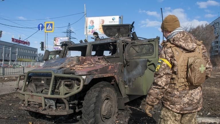 Một binh sĩ Nga kiểm tra xe quân sự bị hư hại ở Kharkiv, Ukraine ngày 27/2 (Ảnh: AP)