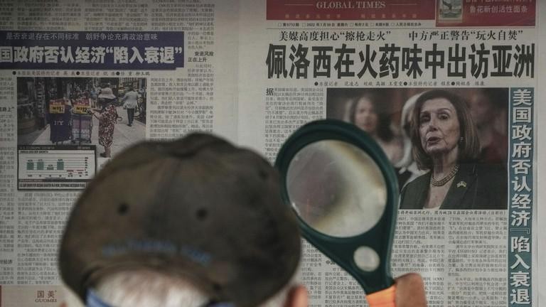 Một người dân đọc tin về bà Pelosi trên tờ Thời báo Hoàn cầu tại một sạp báo ở Bắc Kinh (Ảnh: AP)