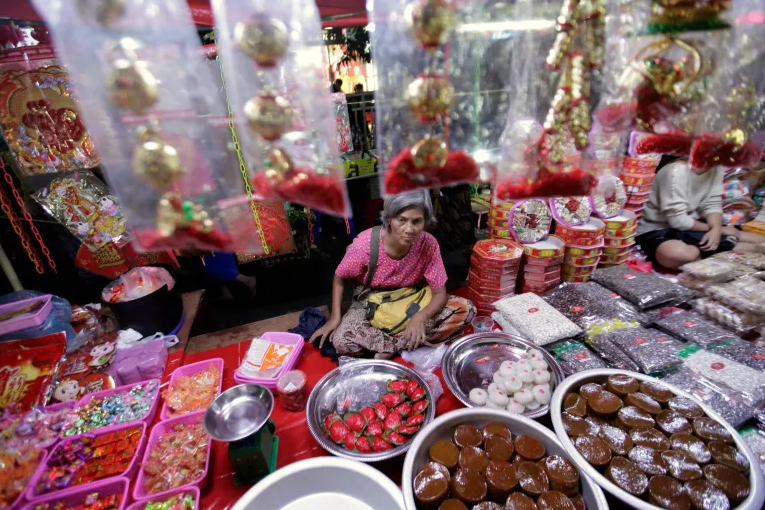 Một người phụ nữ bán đồ ăn nhẹ và quà tặng truyền thống của Trung Quốc trước Tết nguyên đán tại khu phố Tàu ở Yangon, Myanmar (Ảnh: Reuters)