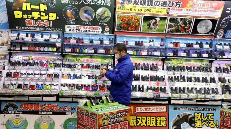 Một nhân viên cửa hàng đứng trước một cửa hàng bách hóa ở Tokyo (Ảnh: Getty)