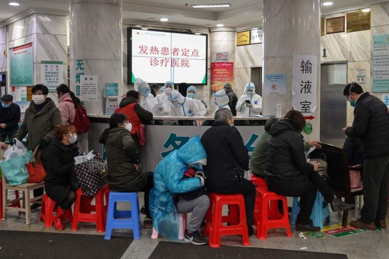Nhân viên y tế cùng người dân tại thành phố Vũ Hán, Trung Quốc. Ảnh: AFP