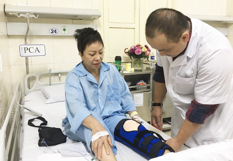 TS.BS. Trần Hoàng Tùng - Phó trưởng Khoa Phẫu thuật Chi dưới, Bệnh viện Hữu nghị Việt Đức - khám lại cho chị Nhung sau 2 ngày phẫu thuật (Ảnh: BVCC) 