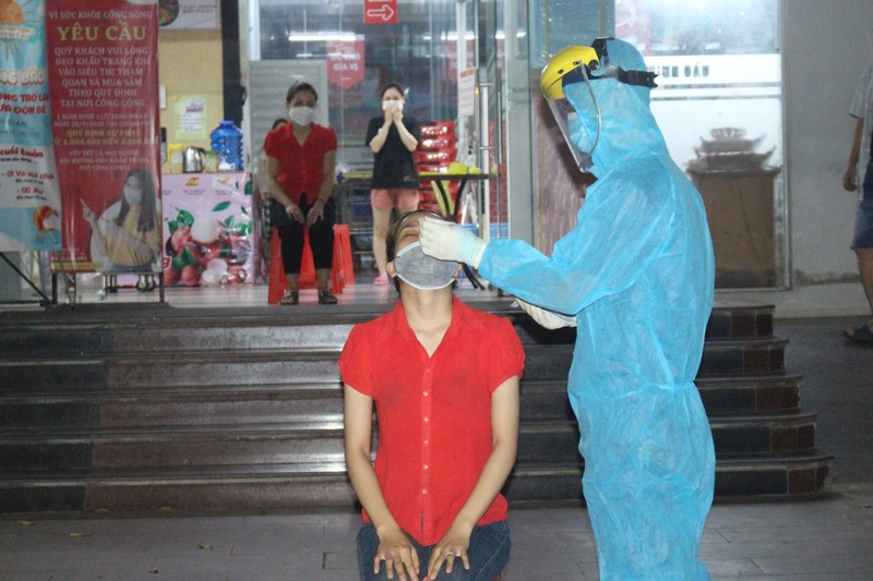 Nhân viên y tế lấy mẫu xét nghiệm COVID-19 cho người dân ở phường Phan Đình Phùng (Ảnh - TNTV) 