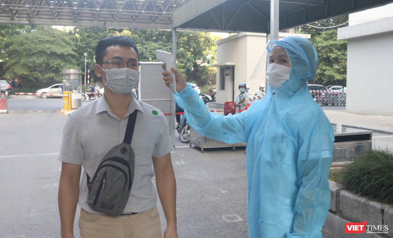 Nhân viên y tế kiểm tra nhiệt độ của người dân trước khi vào bệnh viện (Ảnh - Minh Thuý) 