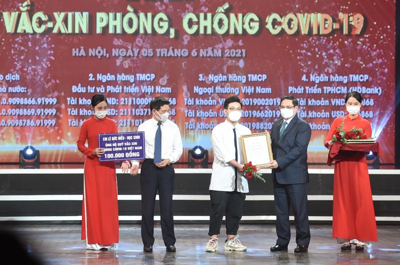 Thủ tướng Chính phủ Phạm Minh Chính trao chứng nhận, cảm ơn em Lê Đức Hiếu (15 tuổi), học sinh Trường Phạm Hồng Thái, Ba Đình, Hà Nội ủng hộ Quỹ vaccine phòng, chống dịch Covid-19.