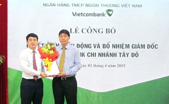 Ông Nghiêm Xuân Thành - Chủ tịch HĐQT VCB (bên trái) trao quyết định và tặng hoa chúc mừng ông Đỗ Trọng Phát - tân Giám đốc VCB Tây Đô