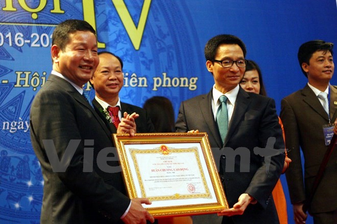 Ông Trương Gia Bình (trái) thay mặt VINASA nhận Huân chương Độc lập hạng Nhì. (Ảnh: Trung Hiền/Vietnam+)