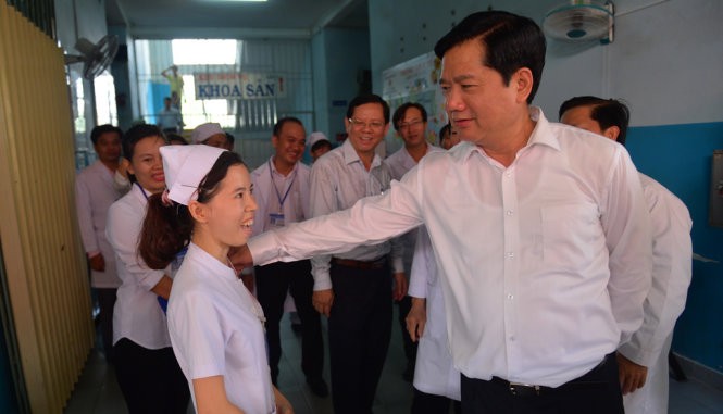 Bí thư Thành ủy TP.HCM Đinh La Thăng hỏi thăm một y tá đang công tác tại bệnh viện sáng 5-6 - Ảnh: QUANH ĐỊNH