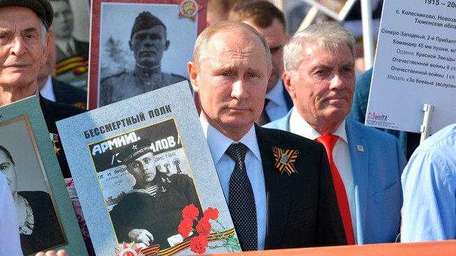 Tổng thống Nga V.Putin mang ảnh người Nga diễu hành cùng với Trung đoàn bất tử nhằm bảo vệ ký ức lịch sử về Ngày Chiến Thắng trong Chiến tranh giữ nước (Ảnh Sputnik)