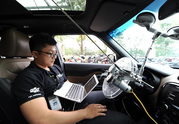 Kỹ sư trẻ Thái Vin đang theo dõi dữ liệu trên máy tính trong khi xe chạy với tốc độ hơn 20km/h ở khuôn viên toà nhà F-Town, quận 9. Ảnh: FPT.