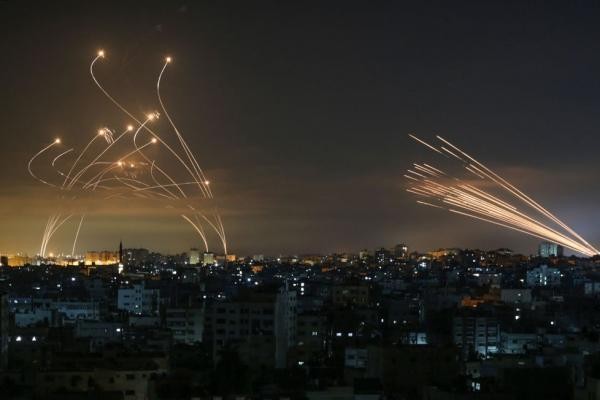 Tên lửa của Hamas phóng từ Dải Gaza (phải) và hệ thống Vòm Sắt phóng tên lửa đánh chặn (trái). Ảnh: AFP.