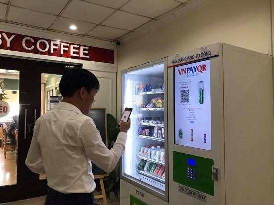 Ông Trần Trí Mạnh, Chủ tịch VNPay dùng QR Code để thanh toán tiền mua hàng qua máy bán hàng tự động.