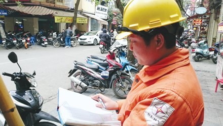 Công nhân Công ty điện lực Hoàn Kiếm đang chốt chỉ số công tơ từng hộ dân trên phố Đường Thành, Hà Nội. 