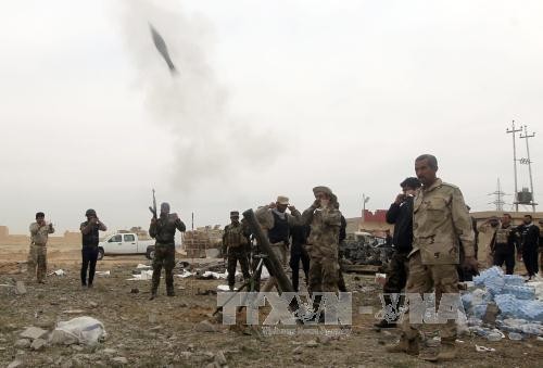 Các lực lượng dân quân người Shiite giao tranh với phiến quân IS tại trung tâm thành phố Tikrit ngày 12/3. Ảnh: AFP/TTXVN.