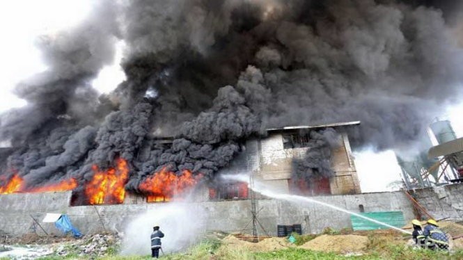 Nhân viên cứu hỏ nỗ lực dập tắt ngọn lửa tại nhà máy ở ngoại ô Valenzuela Ảnh: AFP