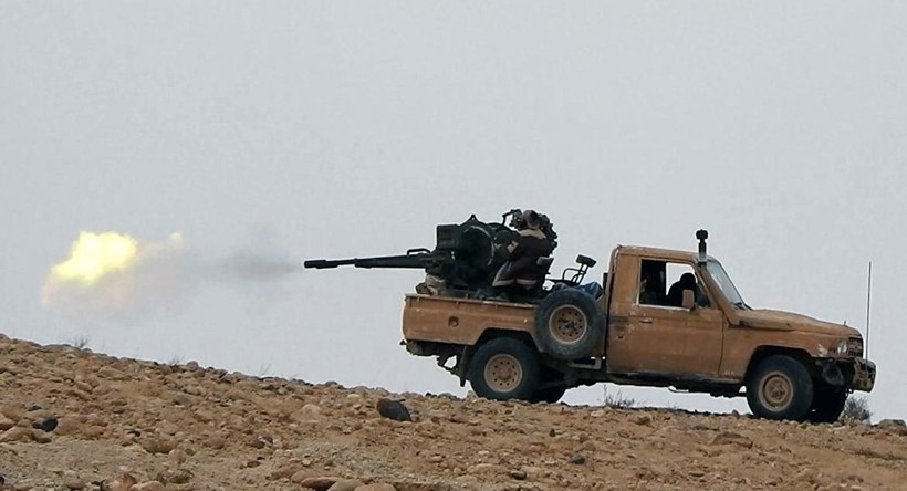 Một binh sĩ Syria đang sử dụng súng máy phòng không trên xe bán tải ở Palmyra
