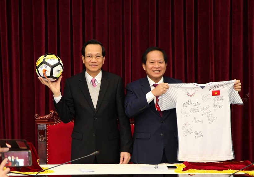  Bộ trưởng Bộ LĐ-TB&XH Đào Ngọc Dung (trái) và Bộ trưởng Bộ Thông tin và Truyền thông Trương Minh Tuấn nhận quả bóng và chiếc áo đấu của U23 Việt Nam tặng Thủ tướng Chính phủ để chuẩn bị đấu giá. Ảnh VGP