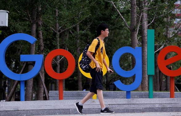 Một thanh niên đi qua khu vực đặt logo Google bên ngoài văn phòng của họ tại thủ đô Bắc Kinh, Trung Quốc - Ảnh: REUTERS