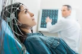 Tổ hợp phục hồi chức năng vận động bao gồm một chiếc mũ có các điện cực và máy điện não đồ - Ảnh: RG