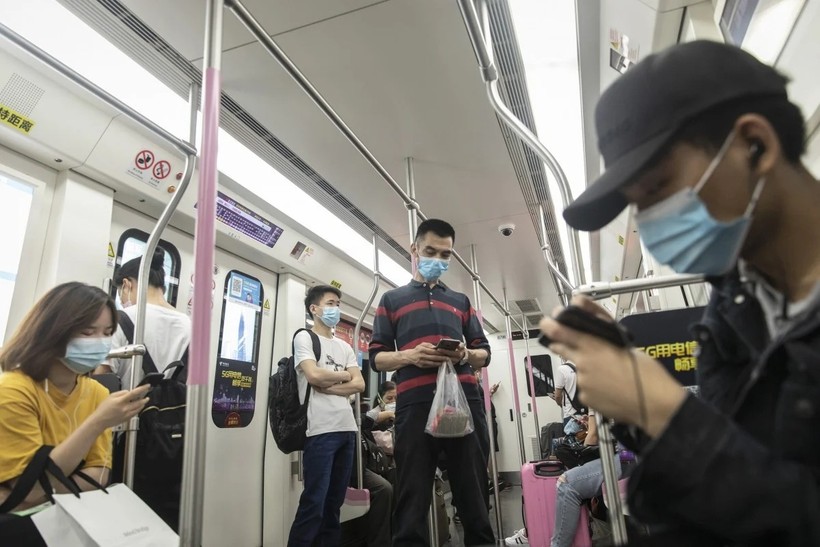 Hành khách sử dụng điện thoại thông minh khi đi tàu điện ngầm ở Vũ Hán ngày 1 tháng 5 (ảnh: Bloomberg)