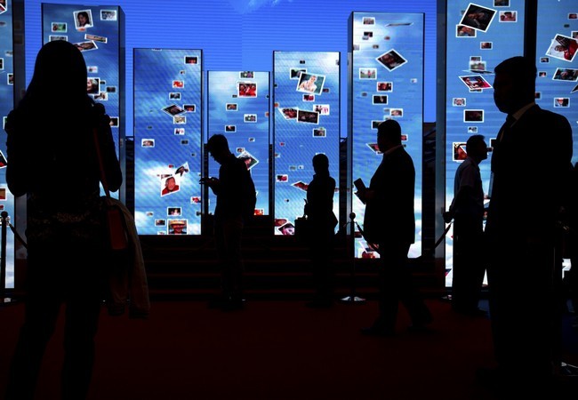 Vì sao con người không thể rời mắt khỏi smartphone? ảnh 2 Khách tham quan bước qua các màn hình video tại một triển lãm trưng bày các thành tựu của Trung Quốc đạt được sau 5 năm dưới sự lãnh đạo của chủ tịch Trung Quốc Tập Cận Bình tại Trung tâm Triển lãm Bắc Kinh, Trung Quốc ngày 28.09.2017 (ảnh AP)