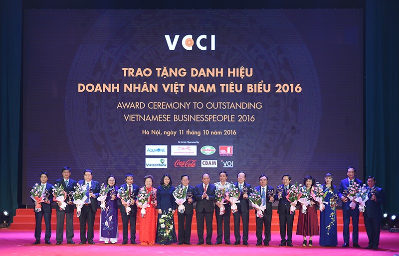 Thủ tướng Nguyễn Xuân Phúc tặng hoa và chụp ảnh lưu niệm với các doanh nhân tiêu biểu.
