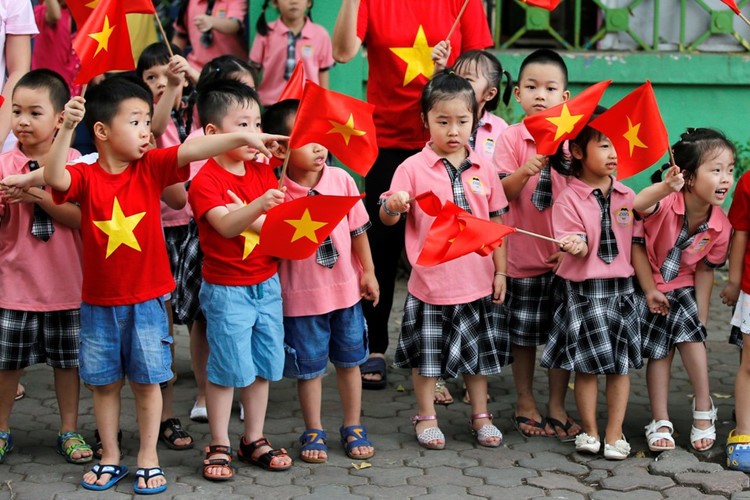 Các em học sinh cầm cờ chào đón Tổng thống Mỹ Barack Obama. (Ảnh: Reuters)