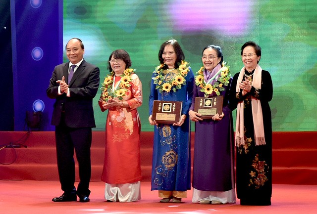 Thủ tướng Nguyễn Xuân Phúc (trái) và Nguyên Phó Chủ tịch nước Nguyễn Thị Doan (phải) tặng hoa cho các phụ nữ điển hình tiên tiến.