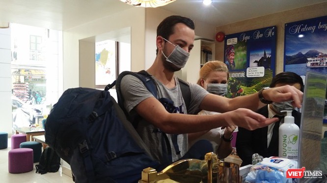Người nước ngoài thực hiện sát khuẩn tay tại một khách sạn ở Hà Nội.