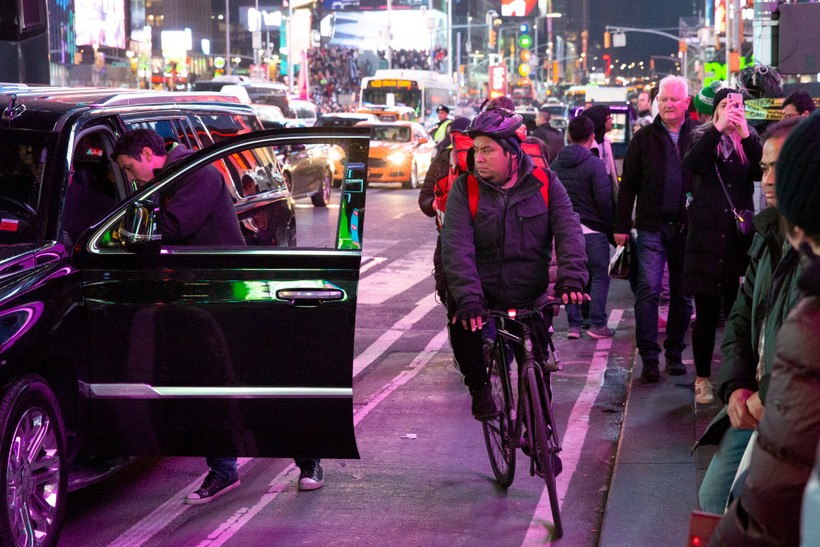 Một người đàn ông đi xe đạp cố gắng luồn lách trên quảng trường Thời Đại, New York (Ảnh: NYPost)