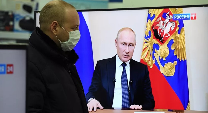 Một người dân theo dõi ông Putin phát biểu trên truyền hình (Ảnh: Sputnik)