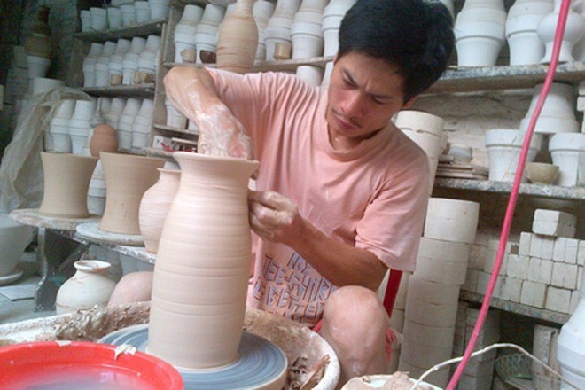 Nghệ nhân Hà Nội Phạm Anh Đạo bên bàn xoay với một sản phẩm gốm được làm theo phương pháp cổ truyền: vuốt- nặn- vẽ- Ảnh nhân vật cung cấp.