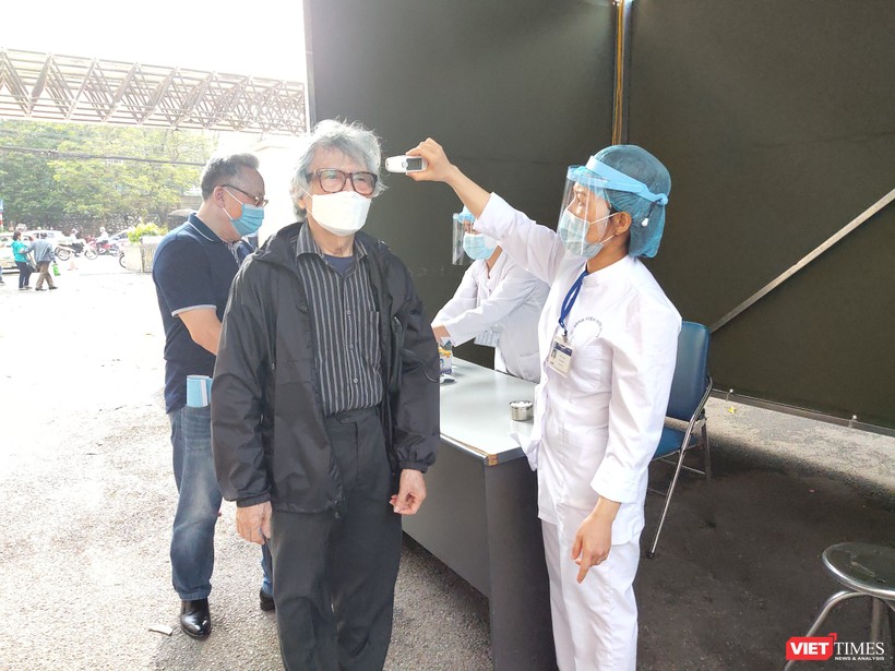 Nhân viên y tế đo thân nhiệt cho người dân tại Bệnh viện Hữu Nghị. Ảnh: Minh Thúy