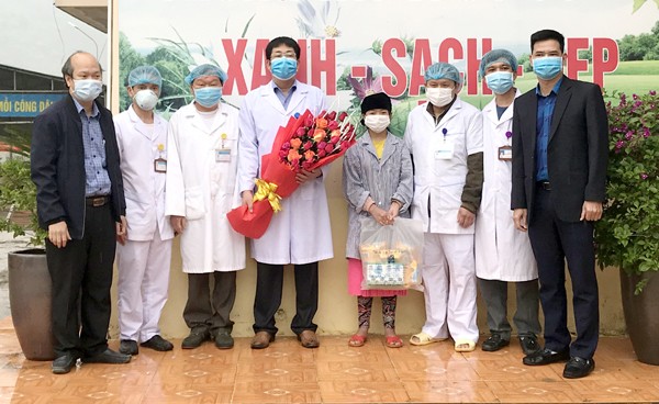 Lãnh đạo huyện Đồng Văn tặng hoa chúc mừng các y, bác sỹ và bệnh nhân 268 (đội mũ đen) được công bố khỏi bệnh vào sáng nay. Ảnh: T.N