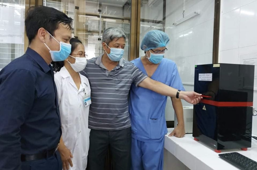 Thứ trưởng Bộ Y tế Nguyễn Trường Sơn (Áo sọc xám) tại buổi khai trương hệ thống xét nghiệm virus SARS-CoV-2 ở Bệnh viện C Đà Nẵng (Ảnh: Vũ Mạnh Cường) 