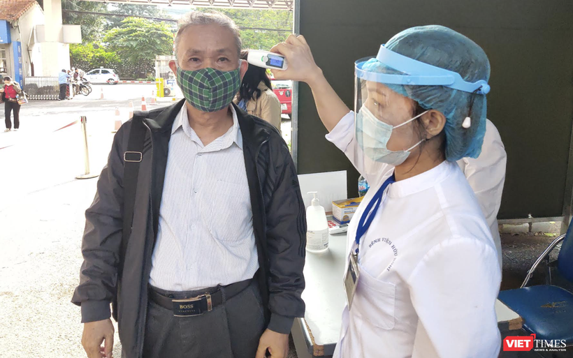 Nhân viên y tế kiểm tra nhiệt độ cho người dân (Ảnh - Minh Thuý) 