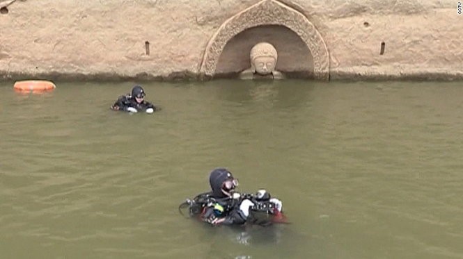 Các chuyên gia khảo cổ học của Trung Quốc mặc đồ thợ lặn nghiên cứu bức tượng - Ảnh: CCTV