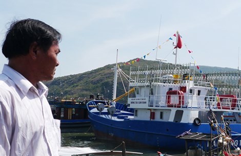Ngư dân Nguyễn Việt Hằng sốt ruột nhìn chiếc tàu 18 tỉ đồng của mình phải nằm bờ hơn bốn tháng nay. Ảnh: TẤN LỘC