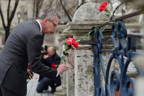 Bộ trưởng Nội vụ Đức đặt hoa viếng các nạn nhân, đa số là người Đức, thiệt mạng trong vụ đánh bom tại quảng trường Sultanahmet, Istanbul hôm 12/1. Ảnh: AFP/TTXVN
