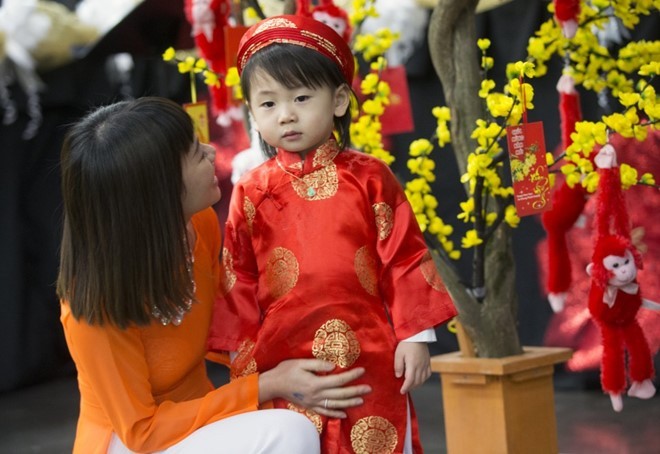 Cô Tran Kim ở thành phố Troutdale dẫn con trai Shane Kim, 2 tuổi, tới tham dự buổi lễ mừng xuân Bính Thân do cộng đồng người Việt tổ chức tại Trung tâm Hội nghị Oregon, thành phố Portland, bang Oregon ngày 6/2. 