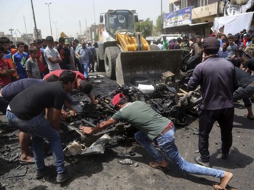 Người dân dọn dẹp sau một vụ đánh bom xe trên đường phố Baghdad hồi tuần trước. Ảnh: AP