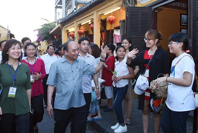 Thủ tướng vẫy tay chào du khách ở phố cổ Hội An.  