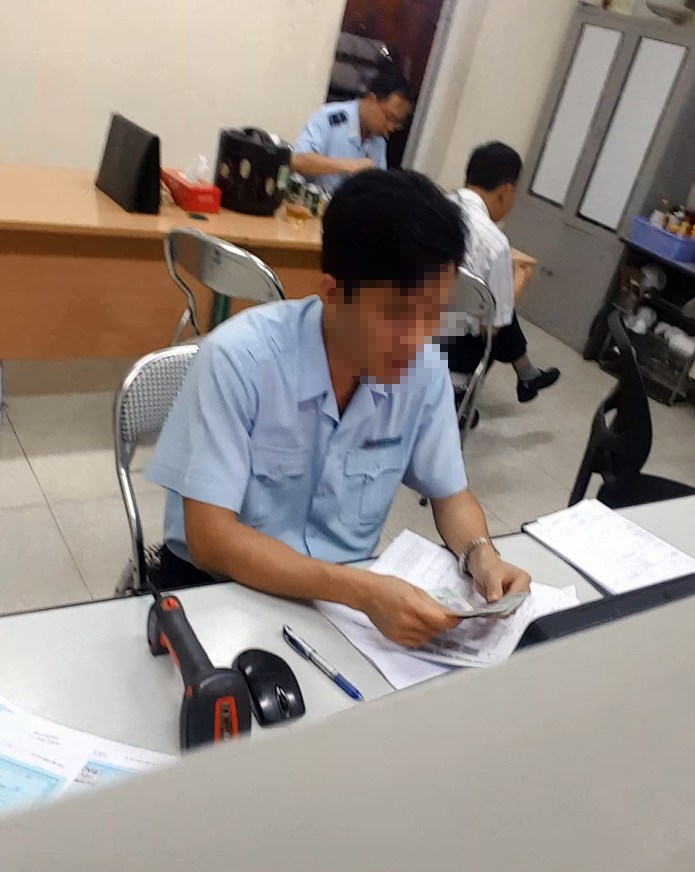 Một nhân viên hải quan đang kiểm tra số tiền hàng triệu đồng vừa được nhân viên “chạy lệnh” nhanh chóng đưa vào. ảnh 7 Một nhân viên hải quan đang kiểm tra số tiền hàng triệu đồng vừa được nhân viên “chạy lệnh” nhanh chóng đưa vào.