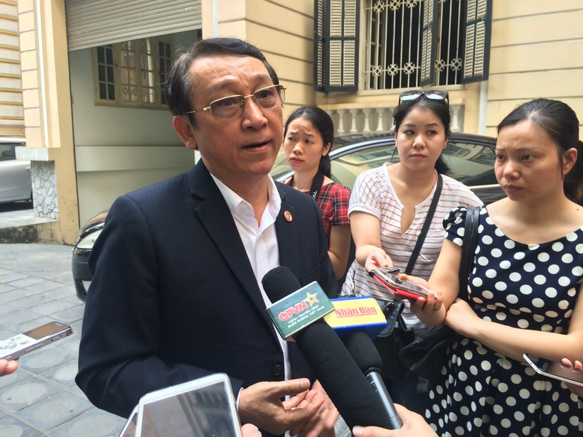 Ông Huỳnh Tấn Vinh trao đổi với cơ quan báo chí bên ngoài hành lang buổi tọa đàm. Ảnh - Quang Vững