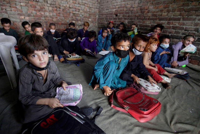 Trẻ em Afghanistan theo bố mẹ chạy sang Pakistan tị nạn (Ảnh Reuters).